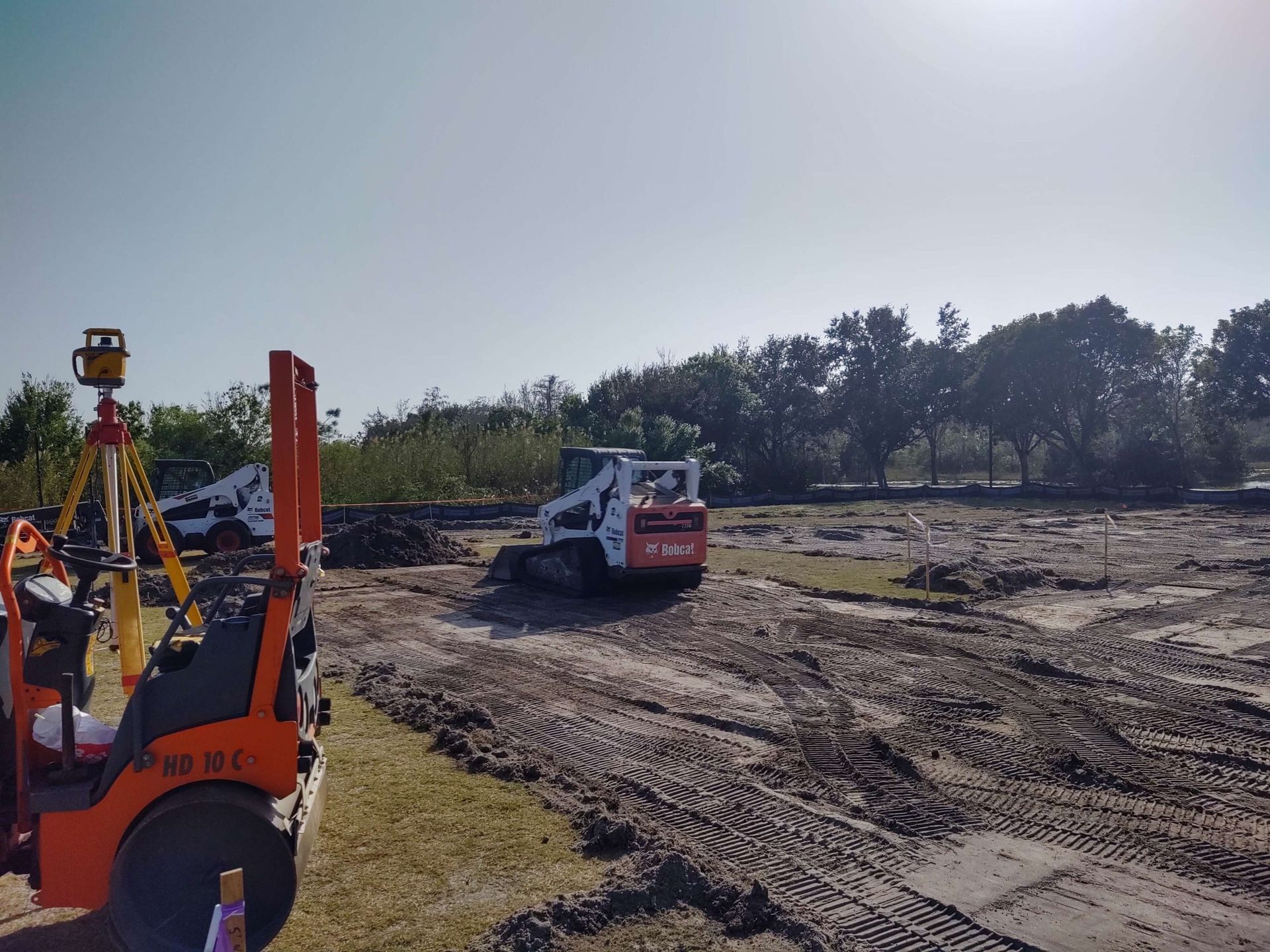 a forklift is parked in the middle of a dirt field.
