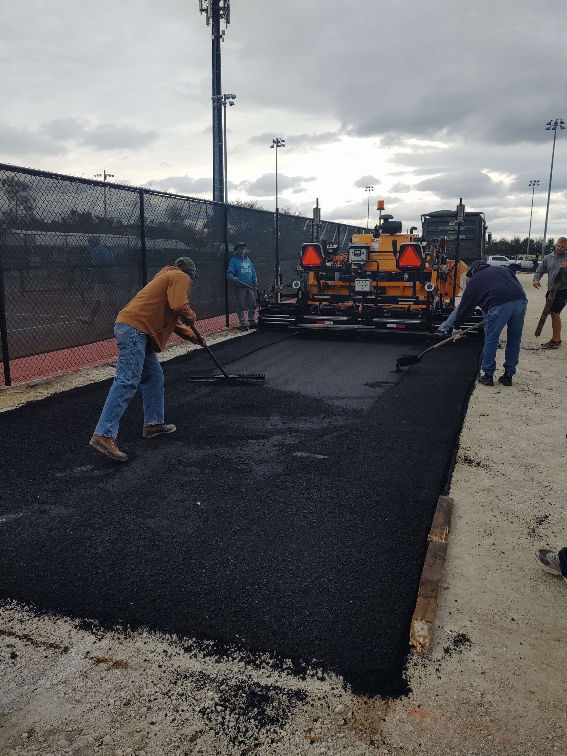 a group of construction workers are working on a road
