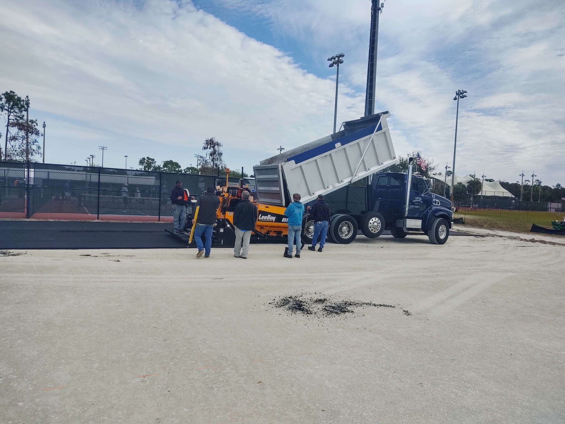 a group of people are standing in front of a dump truck.