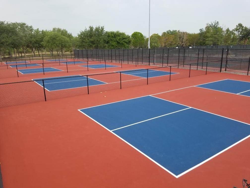 a row of tennis courts with blue and red courts