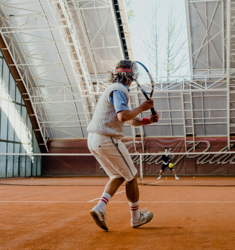 a man is holding a tennis racquet on a tennis court