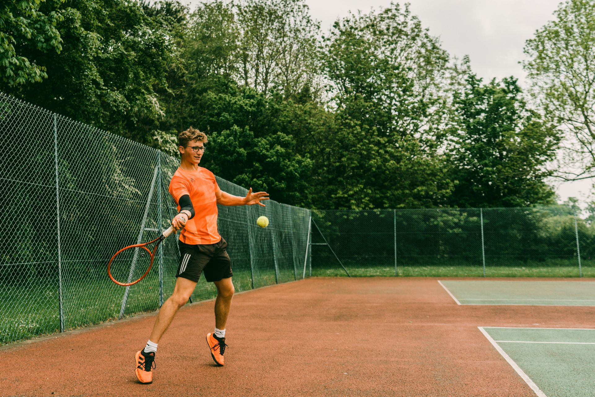 a man is holding a tennis racquet on a tennis court