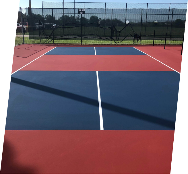 a blue and red tennis court with a fence in the background