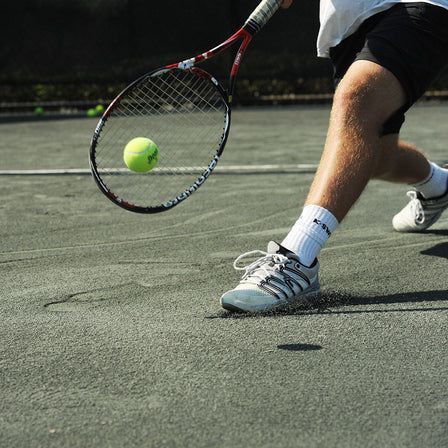 A tennis player is hitting a tennis ball with a racket