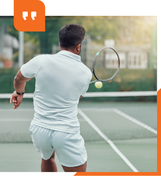 A man is holding a tennis racquet on a tennis court