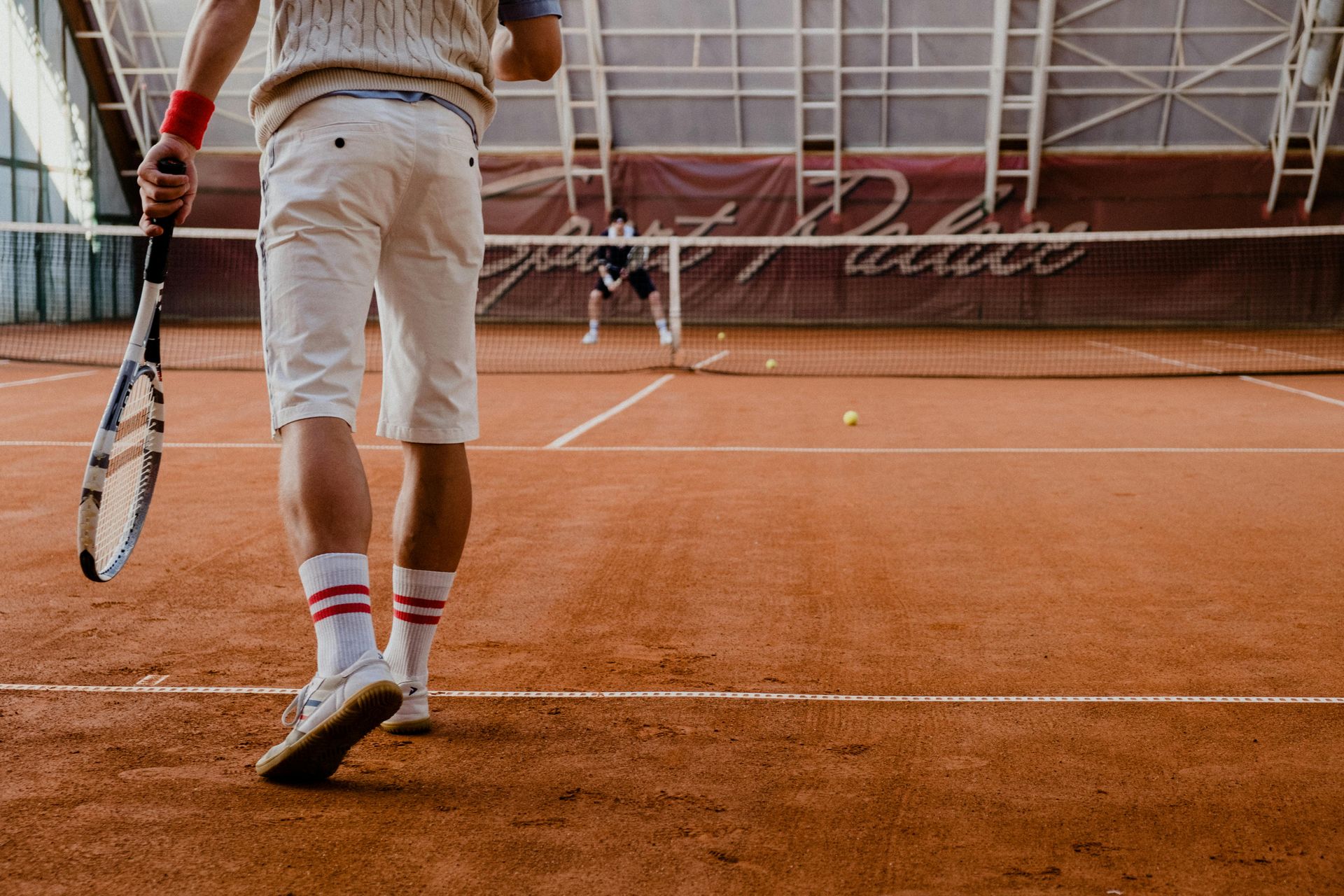 a man is holding a tennis racquet on a tennis court.