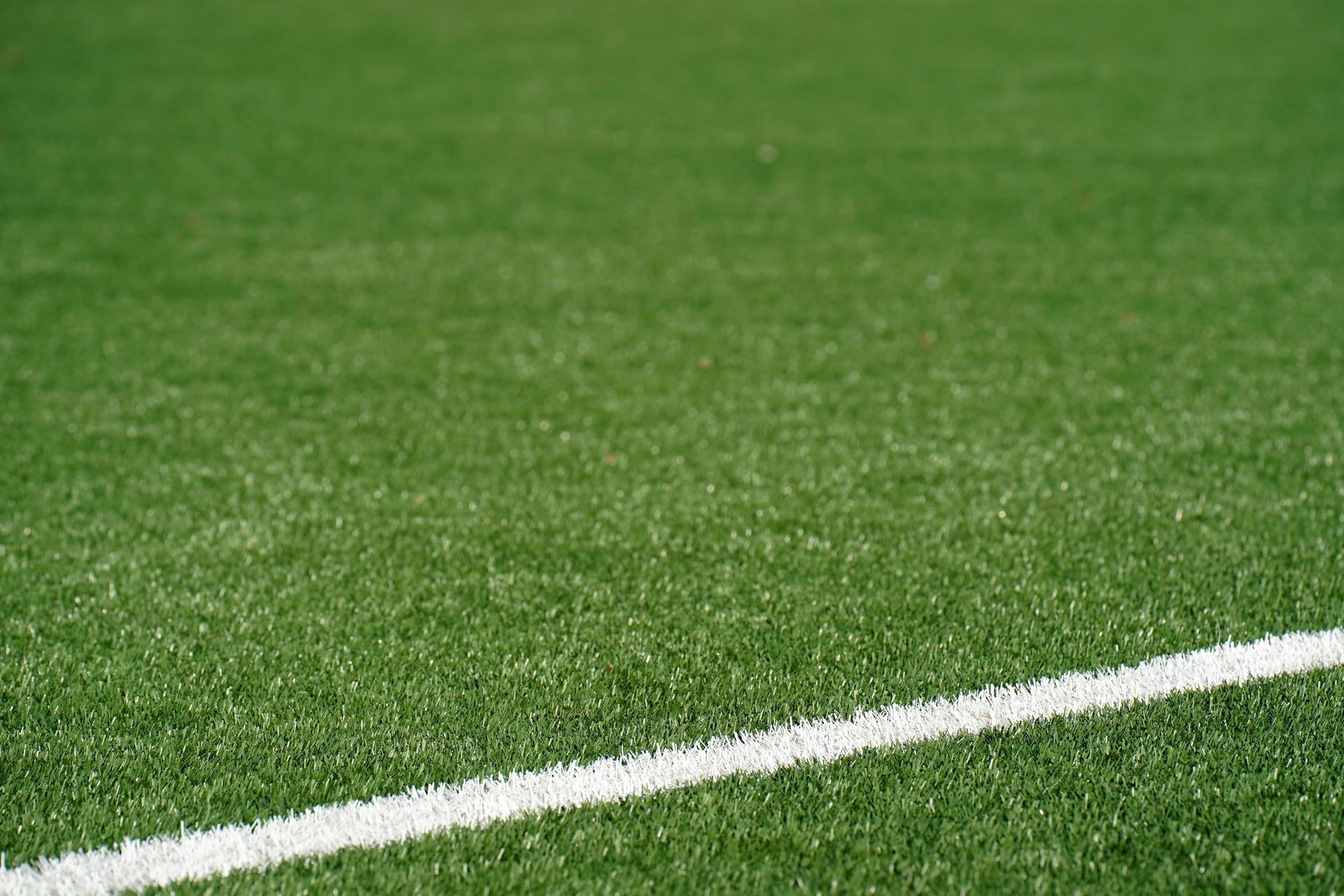 A close up of a soccer field with a white line on it.