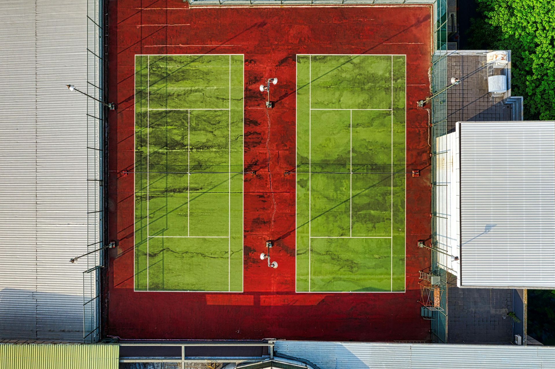 An aerial view of a tennis court surrounded by buildings.