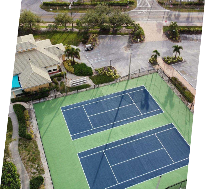 an aerial view of a tennis court with a house in the background
