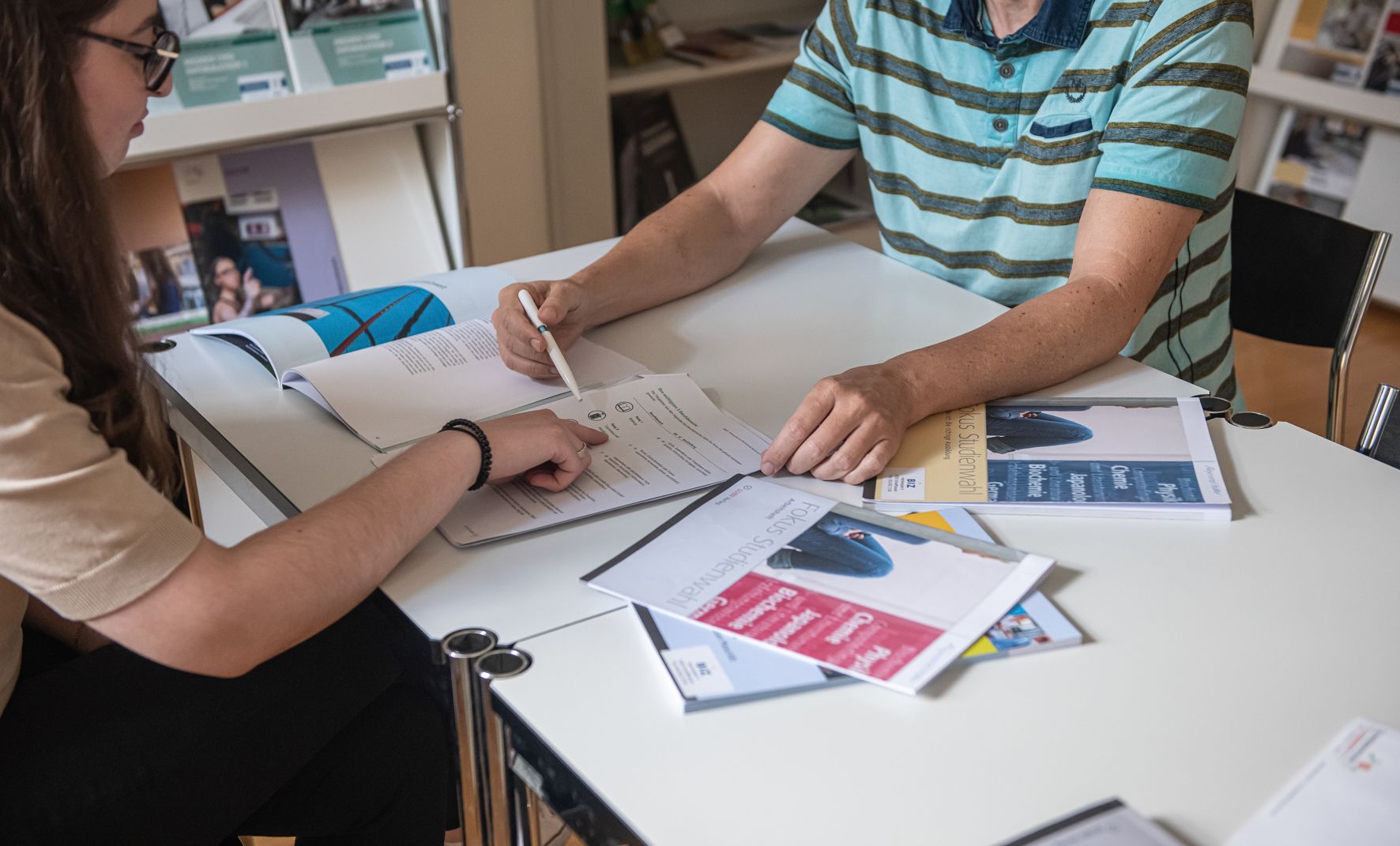 Eine Gruppe von Studenten oder Schülern sitzt an einem Tisch und unterhält sich.