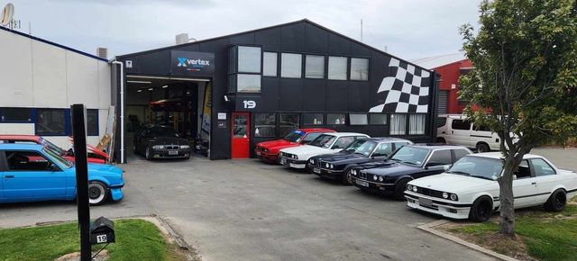 Front of DCH Autosports HQ in Chch with 4 BMW's and a Golf in the carpark 