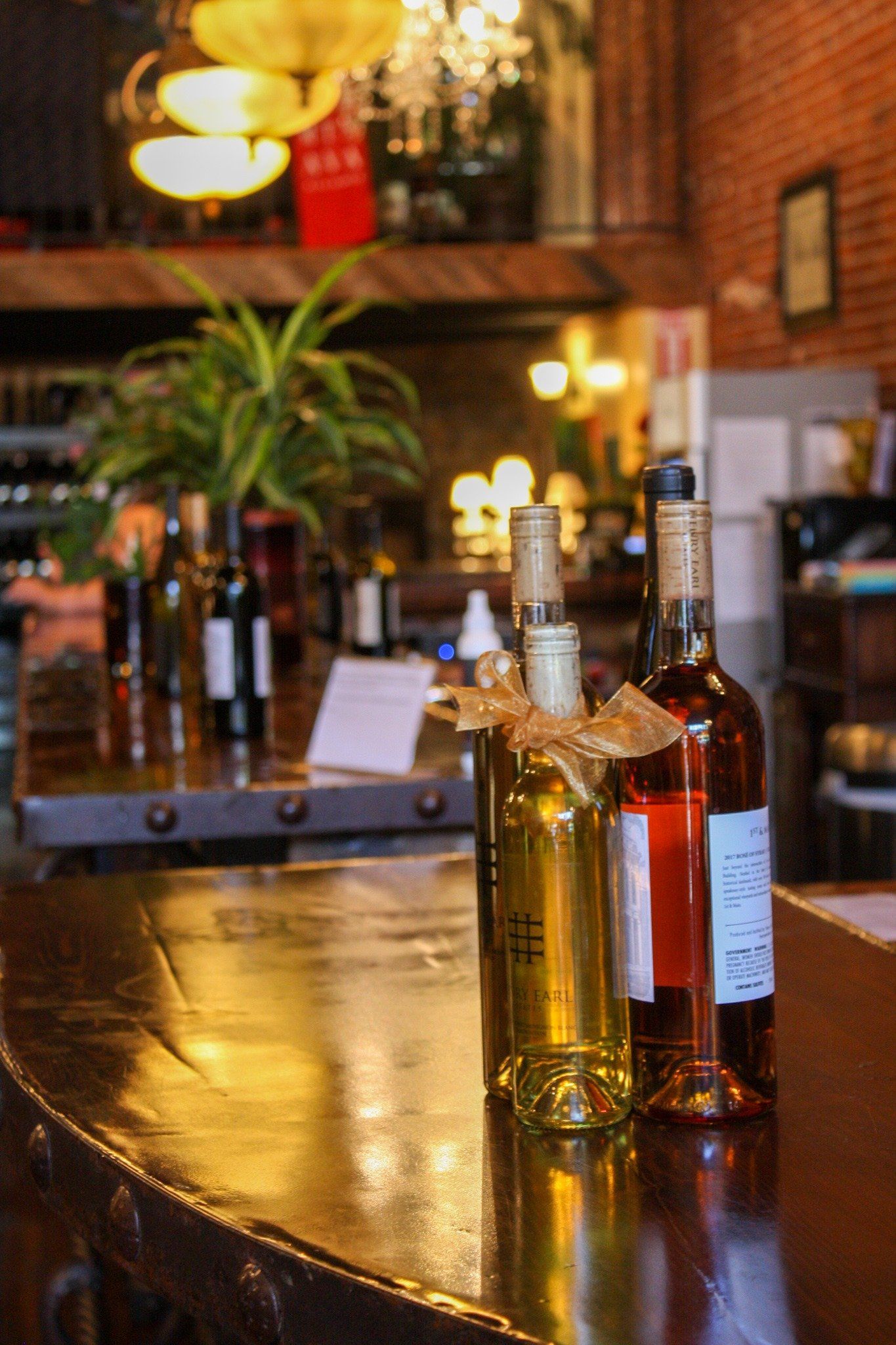 A row of bottles of wine are sitting on a wooden table.