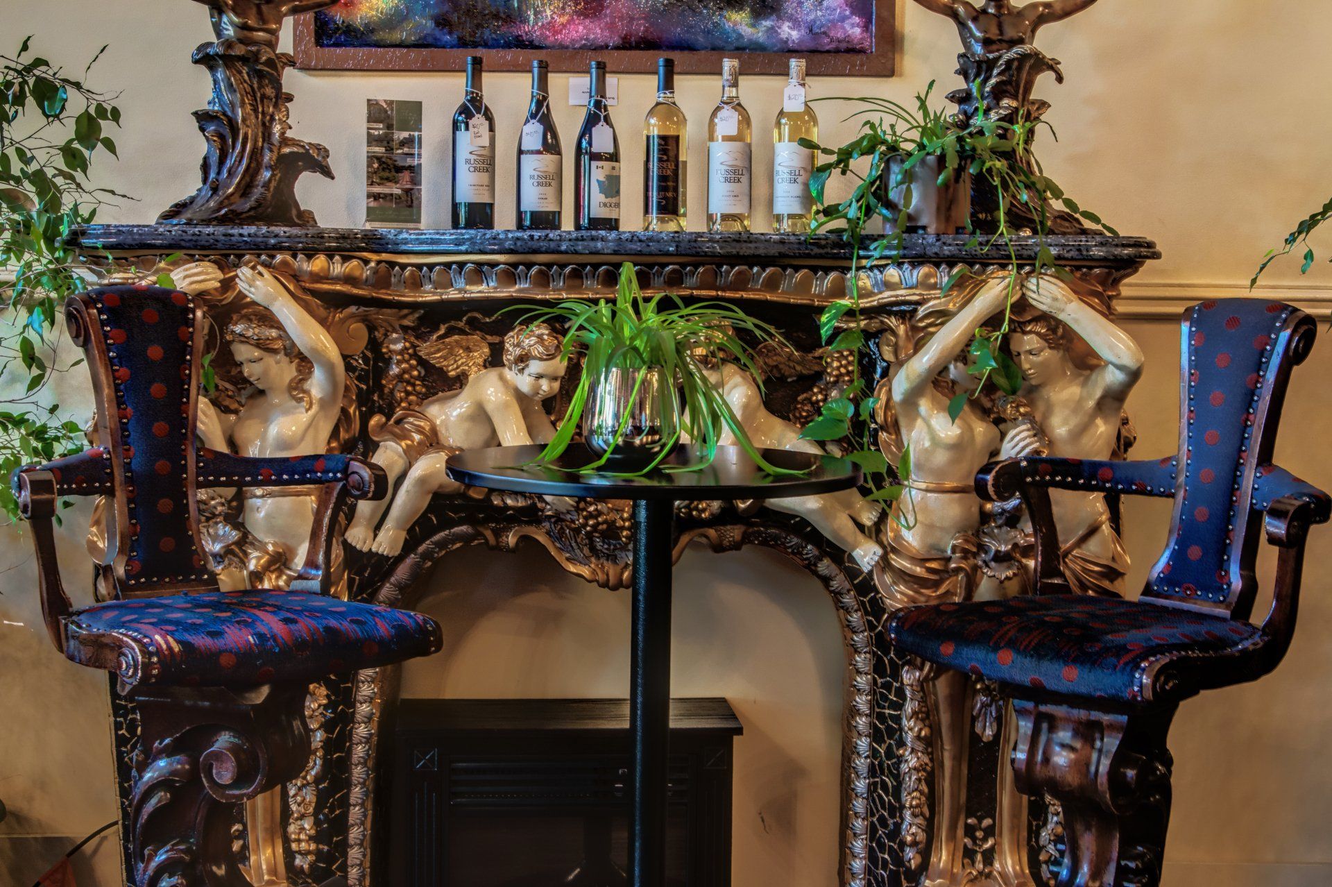 Two chairs are sitting in front of a mantle with bottles on it.