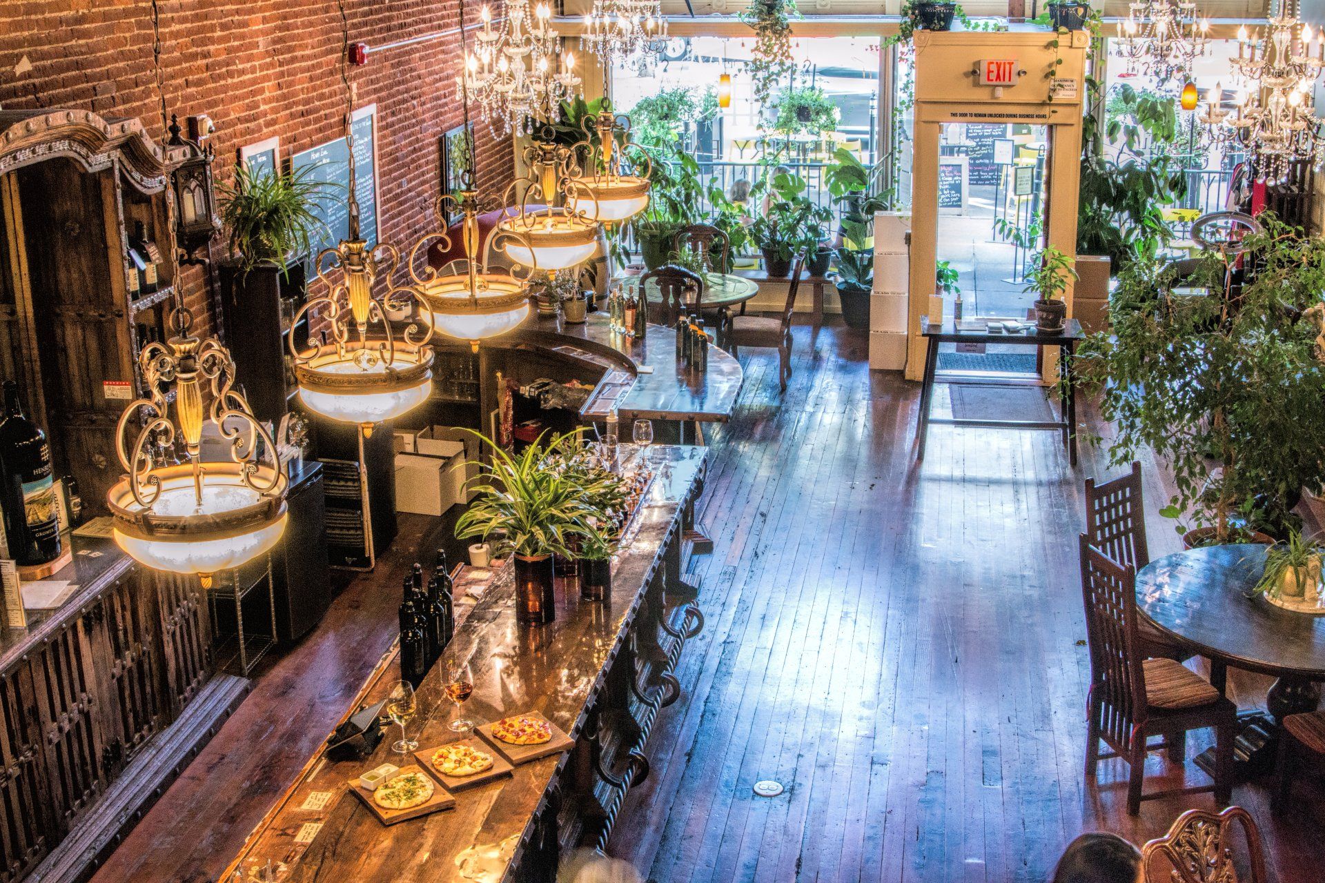 An aerial view of a restaurant with tables and chairs and lots of plants.