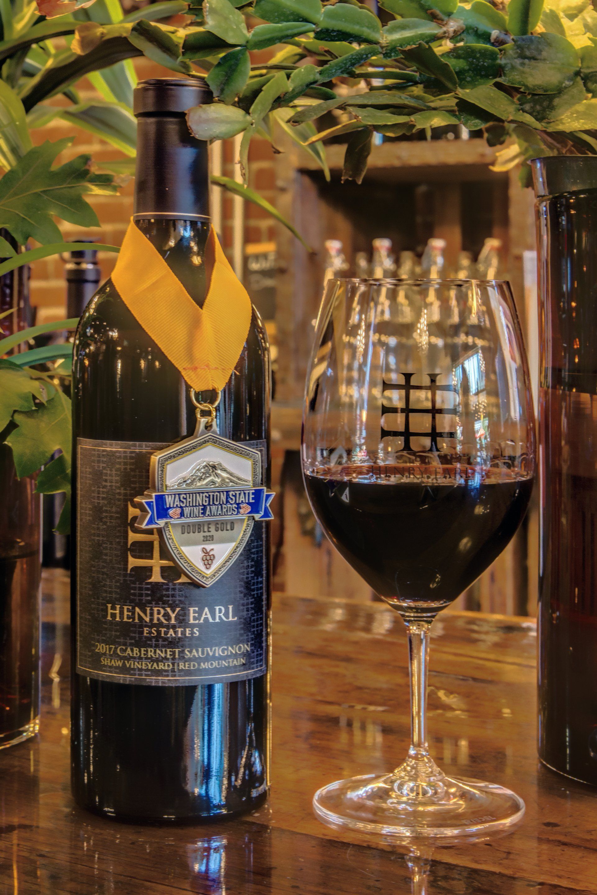 A bottle of wine and a glass of wine are on a table.