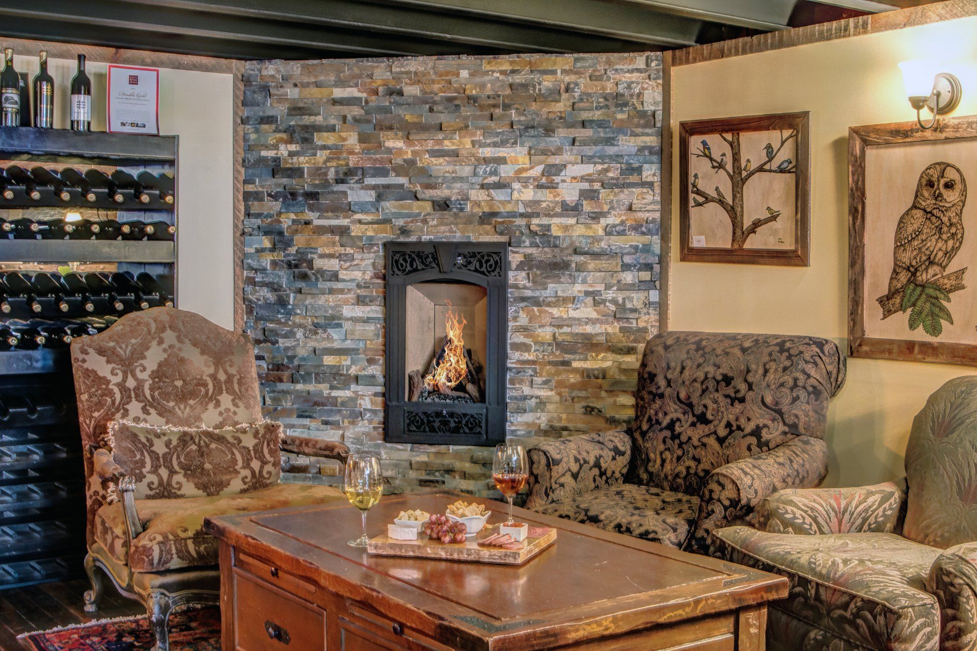 A living room with a fireplace , chairs and a table.