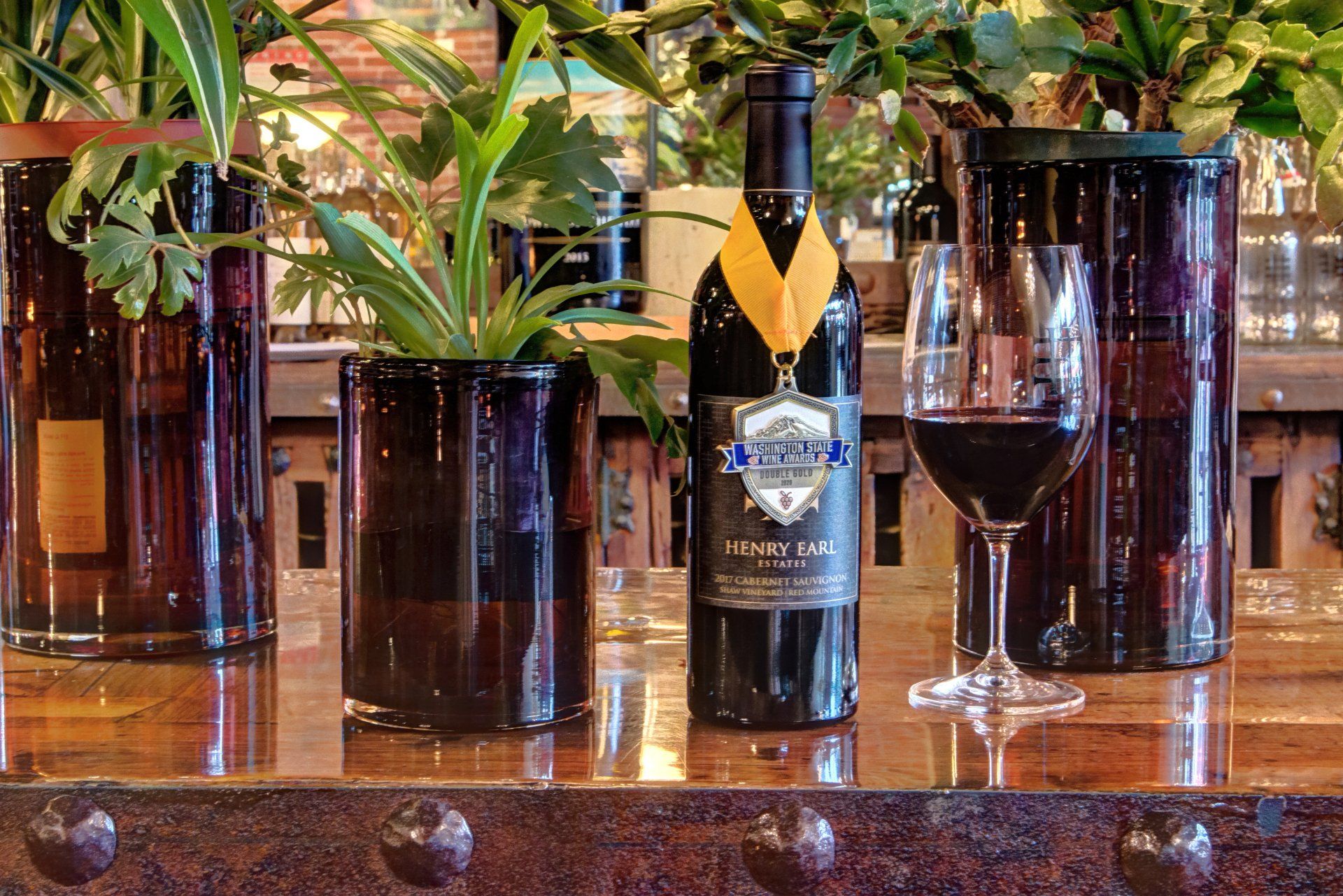 A bottle of wine is sitting on a table next to a glass of wine.