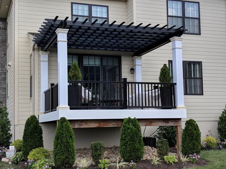 A house with a large porch with a pergola over it