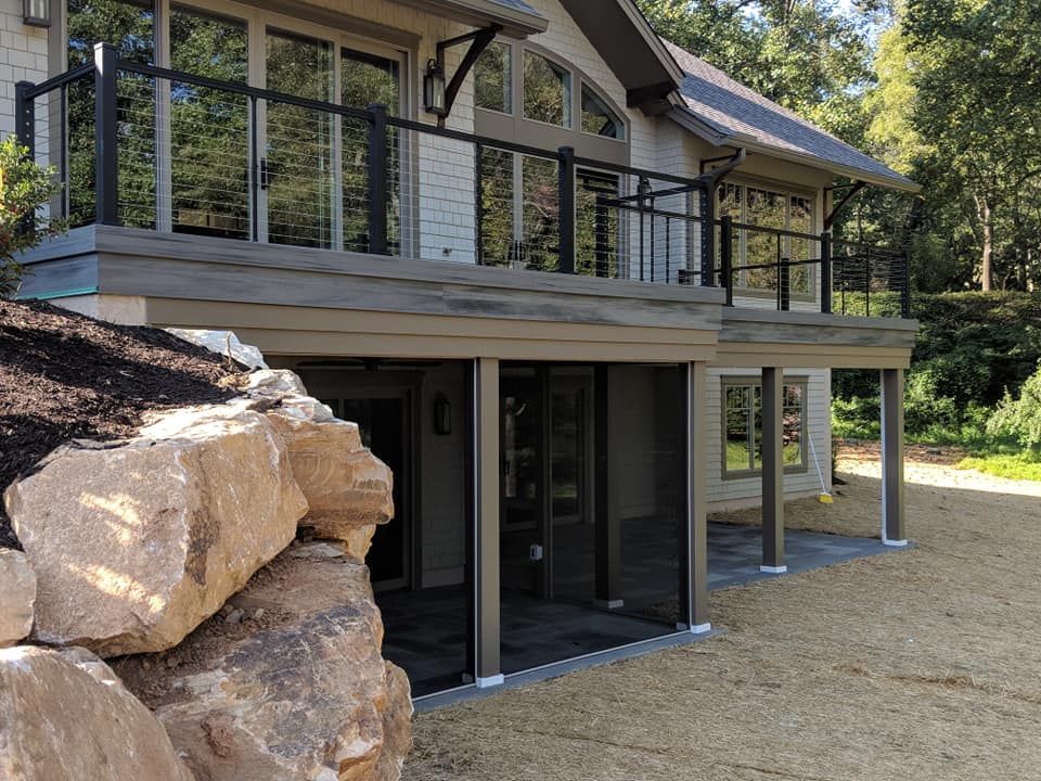 A white house with a large deck in front of it.