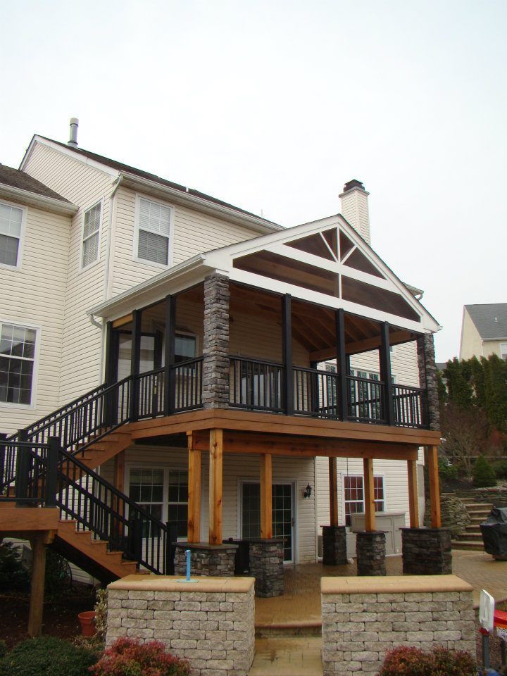 A white house with a large deck and stairs