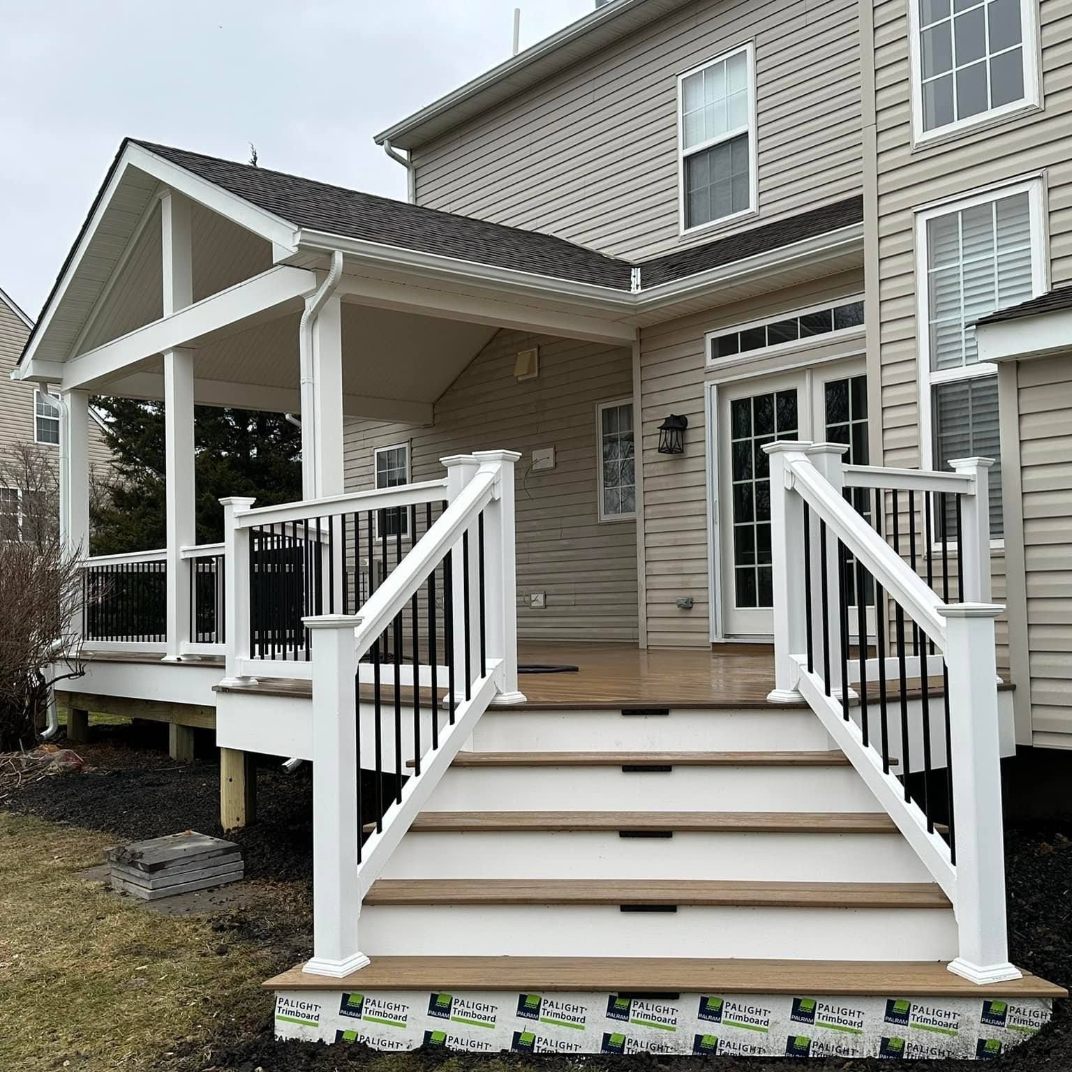 A large house with a porch and stairs leading up to it.