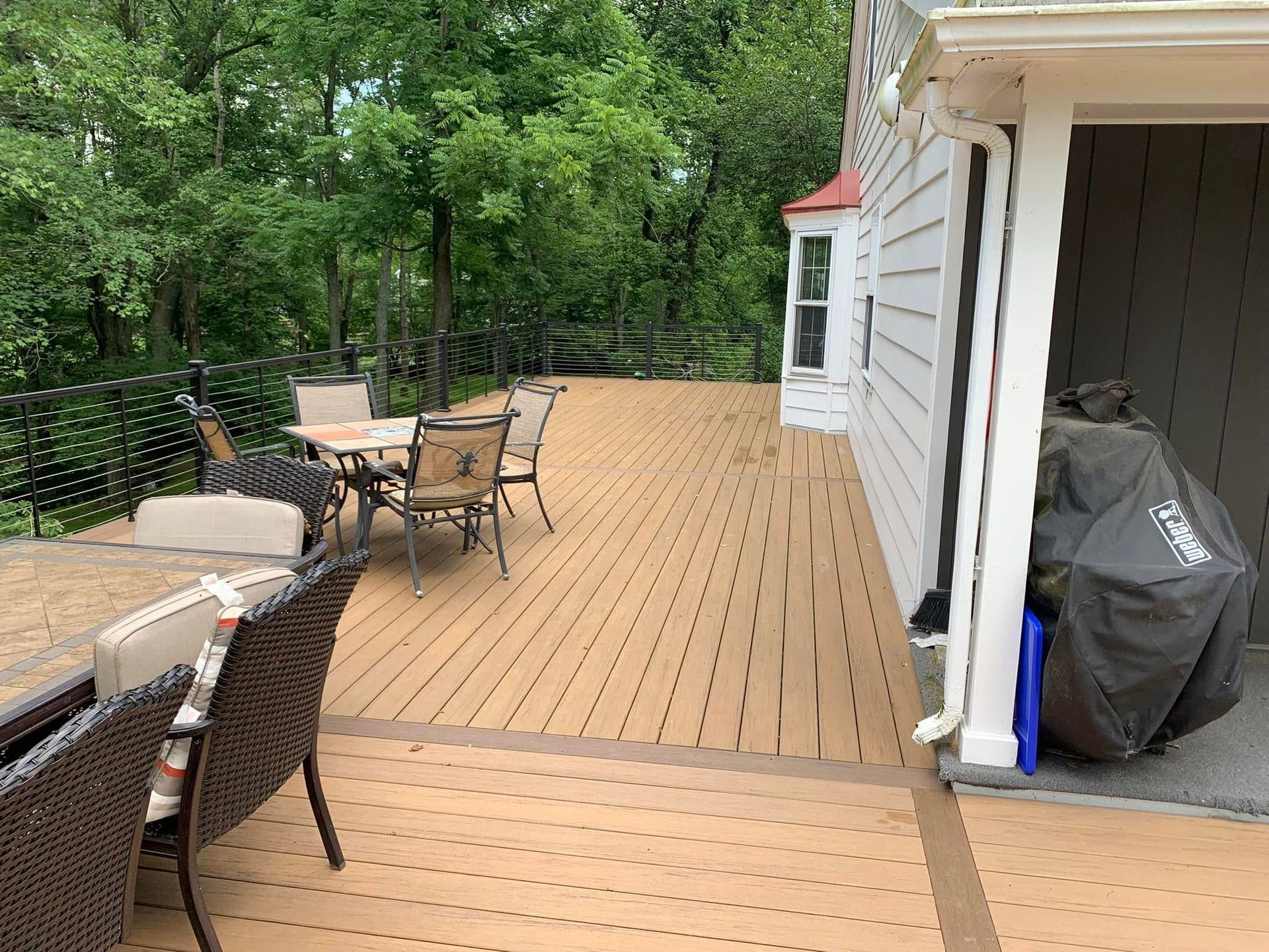 There is a large deck with a table and chairs on it.