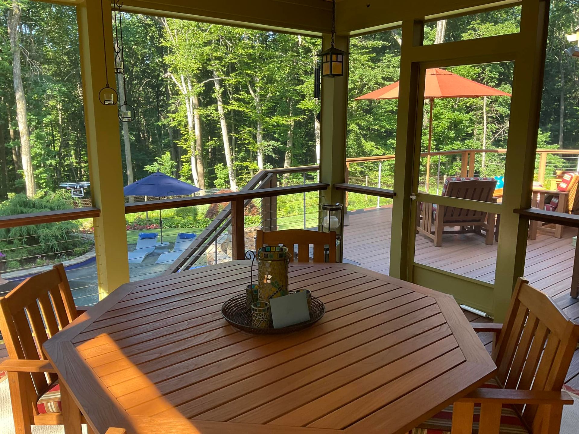 A grill is sitting on a wooden deck next to a house.