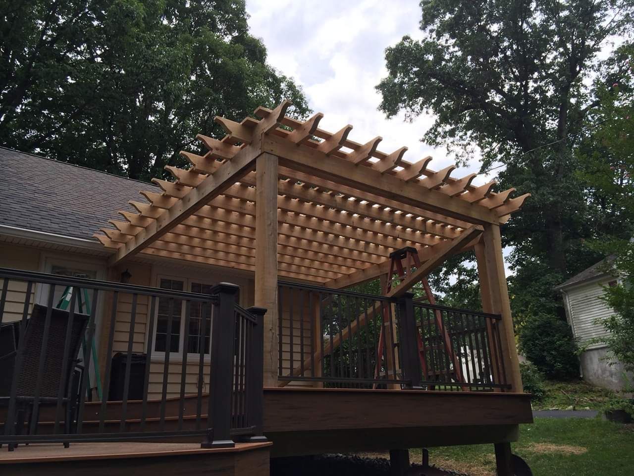 A wooden deck with a pergola on top of it