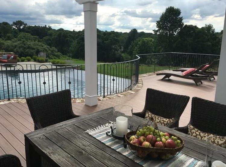A fire pit is sitting on top of a wooden table on a patio.