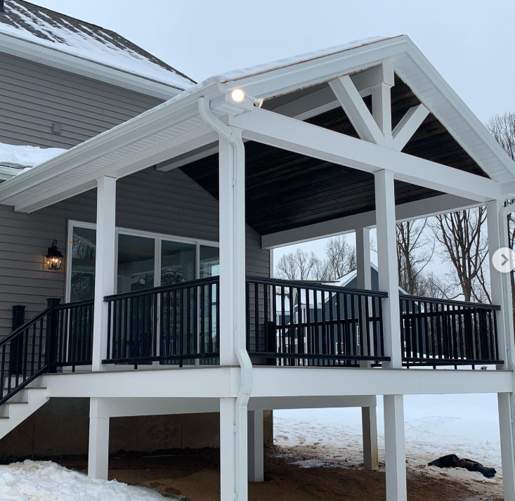 A wooden deck is being built in front of a house.