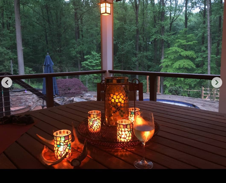 A wooden deck with chairs and a fireplace