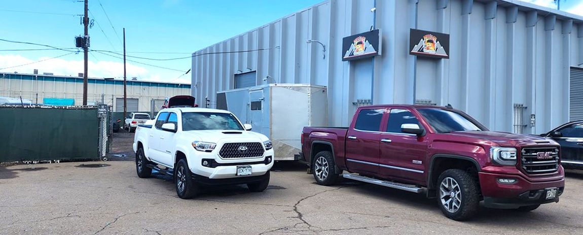 Two trucks are parked in front of a building.