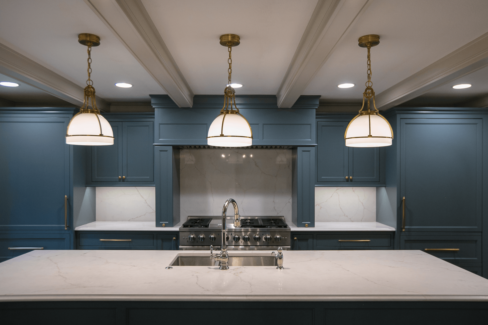 Marble Kitchen Island With Hanging Lights & Blue Accents Remodeled By New Beginnings in Columbia, MO