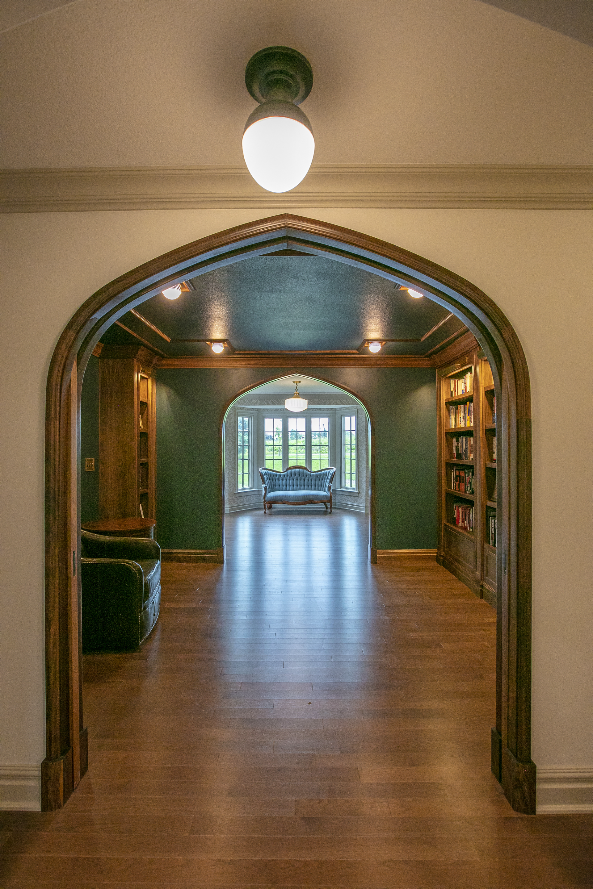 Elegant Hallway With a Library & an Antique Couch at the End, Renovated by New Beginnings in Mid-MO