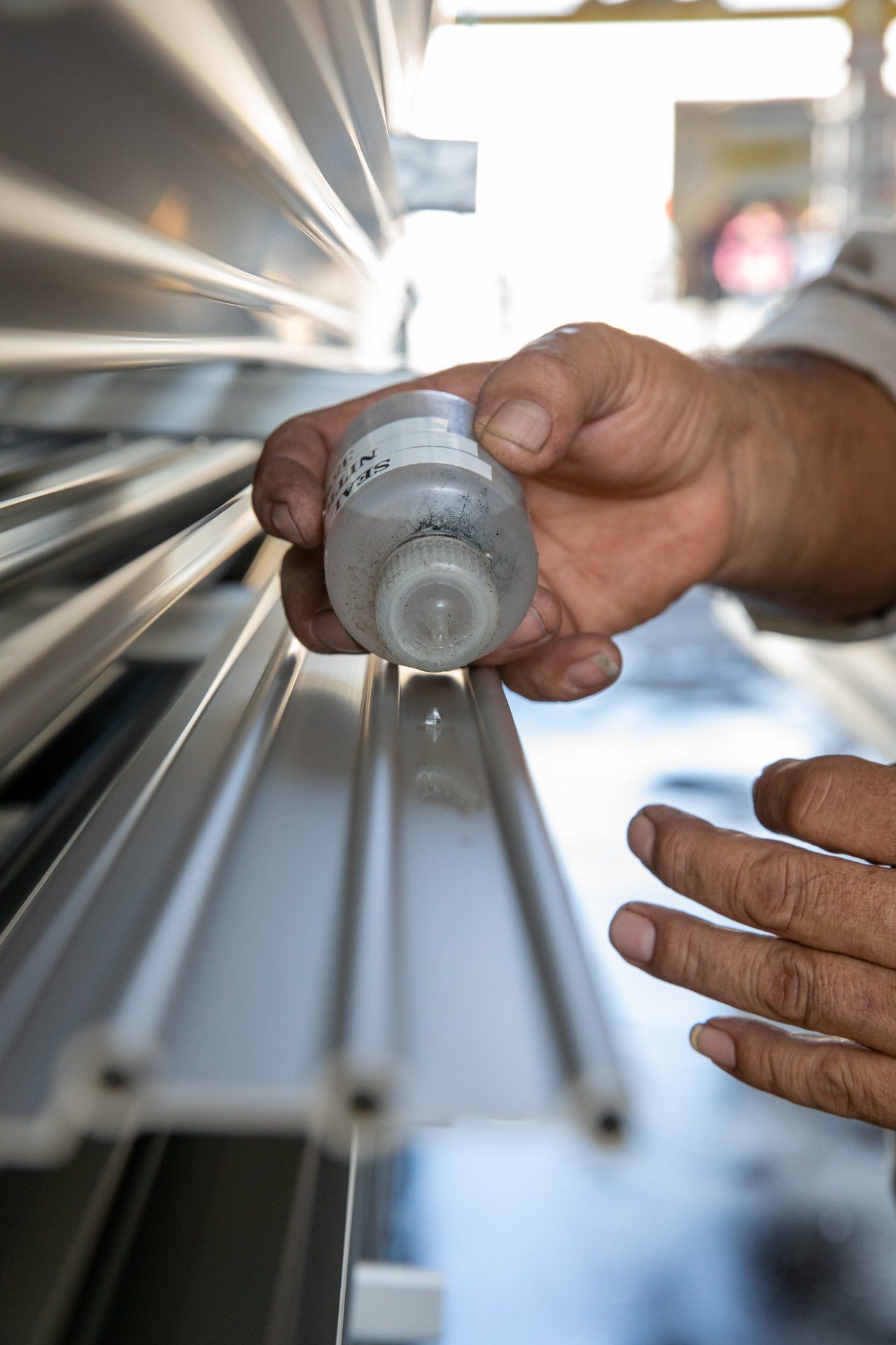 Hand holding small bottle to test metal