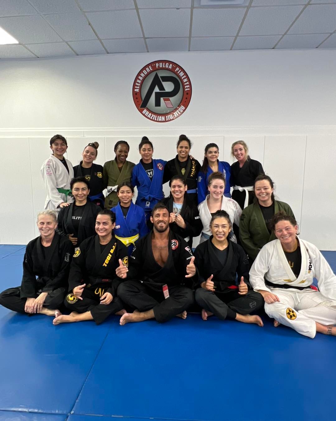 A group of people are posing for a picture in a gym.