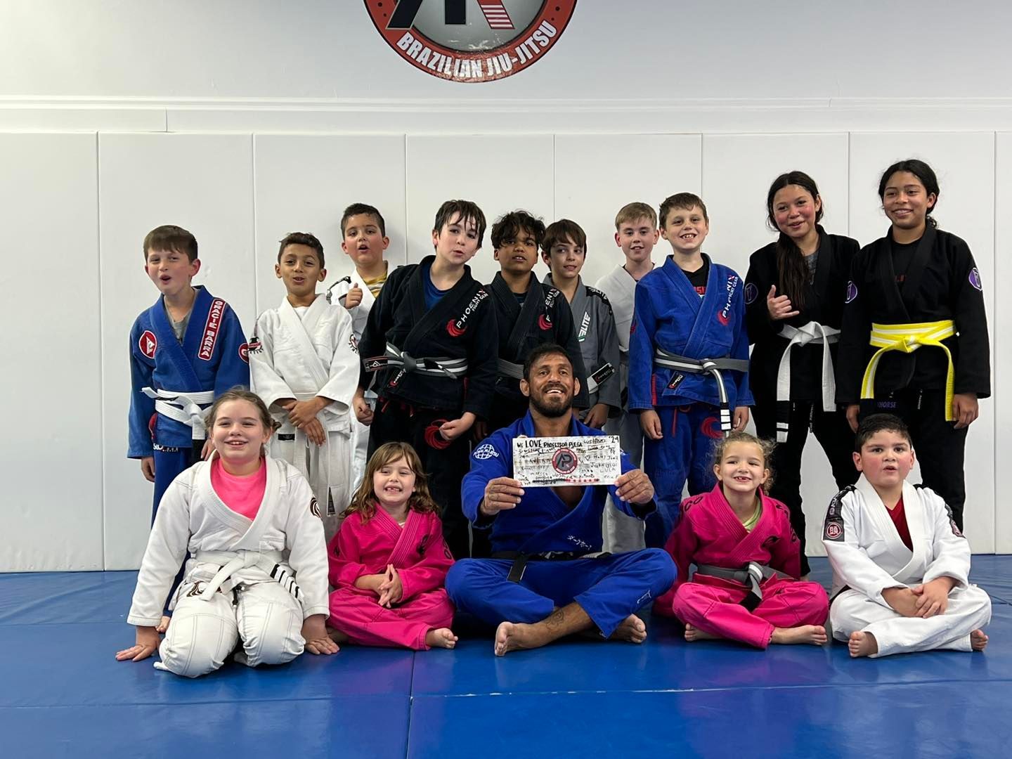 A group of children in karate uniforms are posing for a picture.