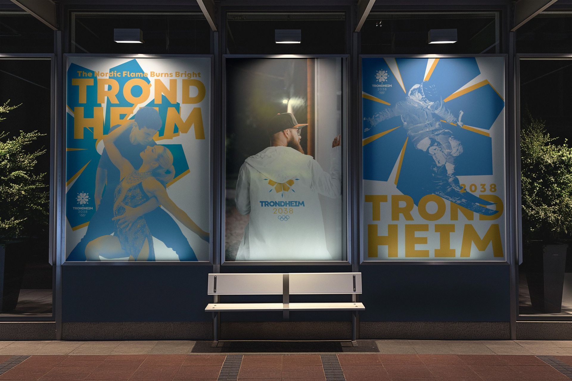 Three storefront posters for Trondheim, blue and gold, with a bench centered beneath them