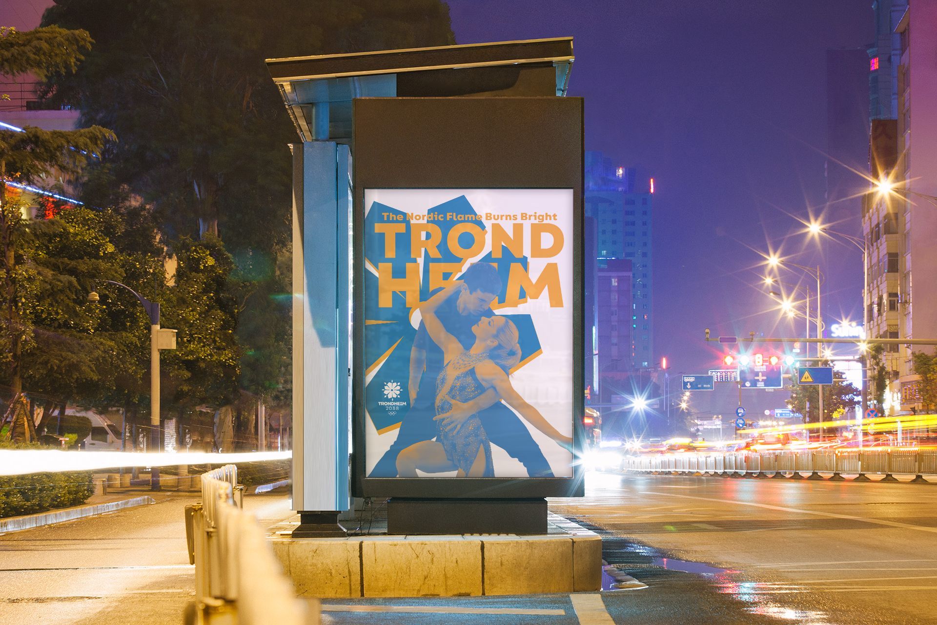 Nighttime city bus shelter with a colorful poster, blurred traffic lights, and a wet street.