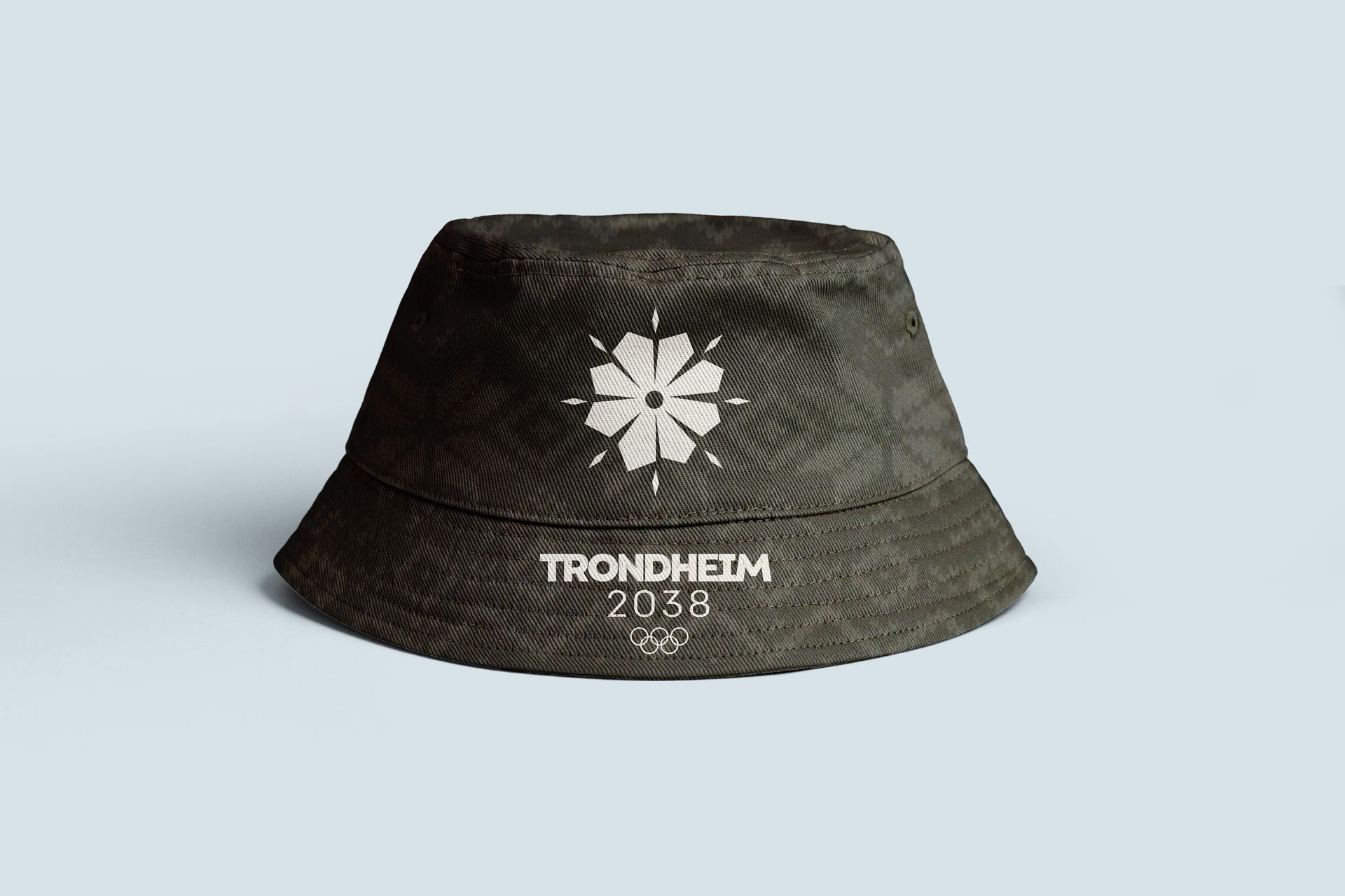 Dark camo bucket hat with white logo and “TRONDHEIM 2030” text on a light background