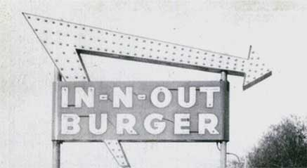 Vintage In-N-Out Burger sign with arrow on pole in black and white