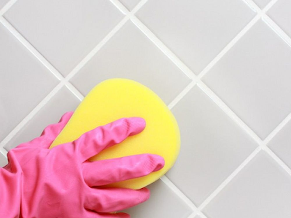 A Person Wearing Pink Gloves Is Cleaning A Tile — Alta Cleaning Service In Coconut Grove, NT