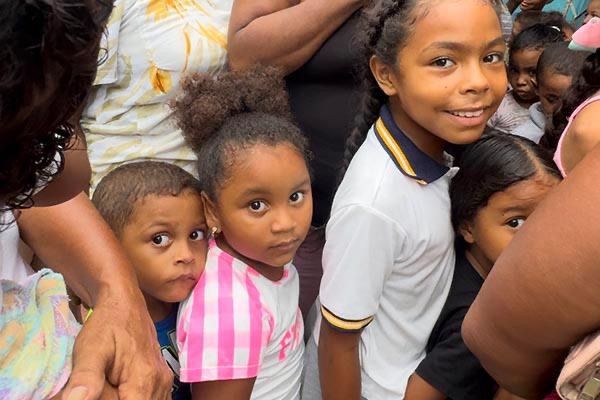 A group of children are standing next to each other and looking at the camera.