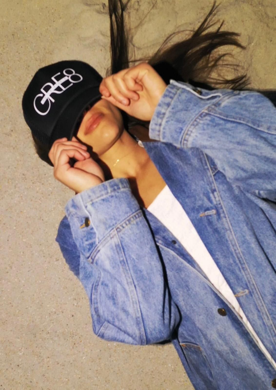 A woman wearing a black hat that says cre8