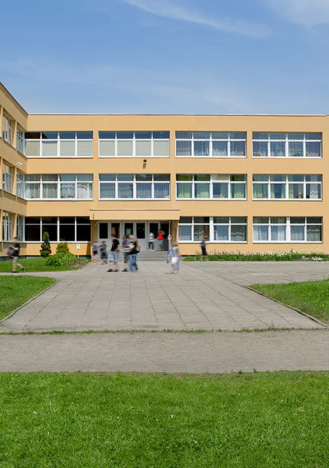 A large building with a lot of windows and people walking in front of it.