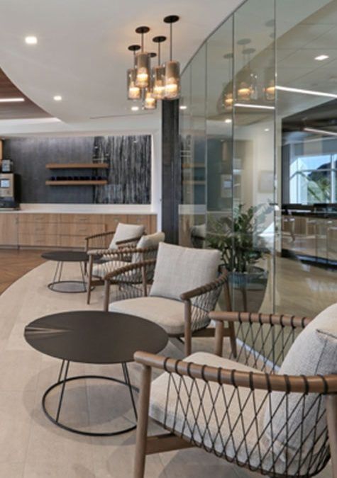 A row of chairs and tables in a room with a glass wall