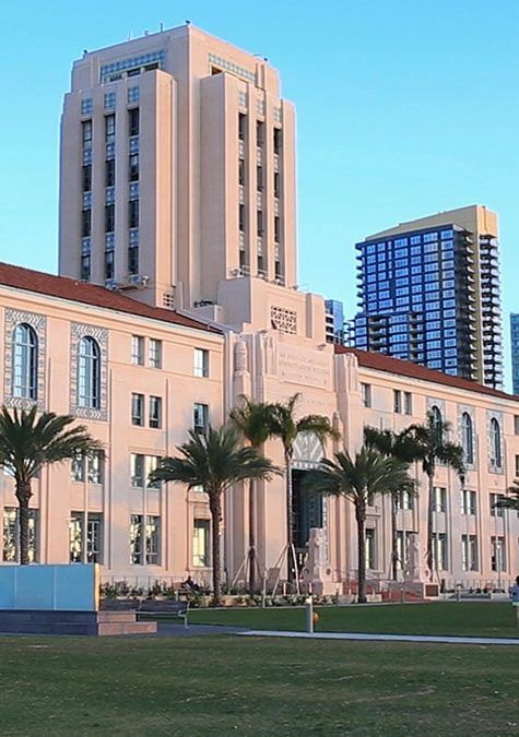 A large building with a few palm trees in front of it