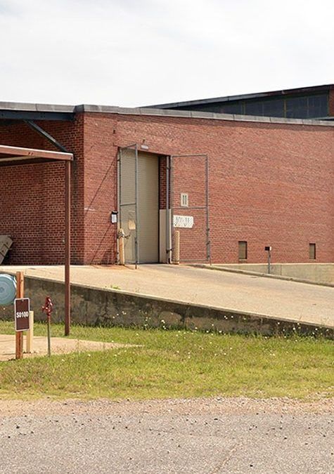 A large brick building with a loading dock in front of it.