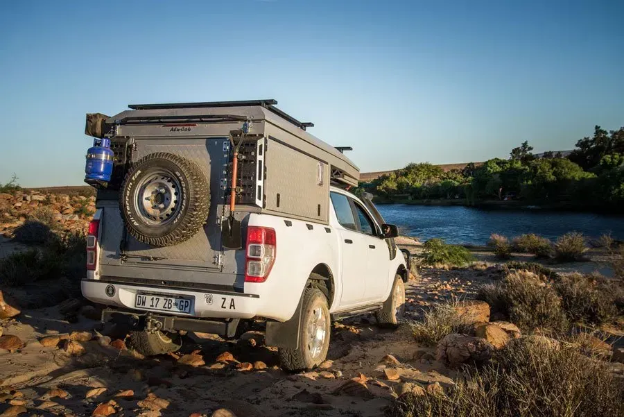 A White Truck With a Canopy on Top of It is Parked Next to a Body of Water — Whitsunday 4x4 & Automotive In Cannonvale, QLD