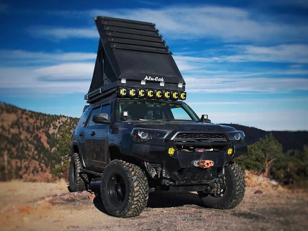 A Black SUV With a Tent on Top of It is Parked on a Dirt Road — Whitsunday 4x4 & Automotive In Cannonvale, QLD